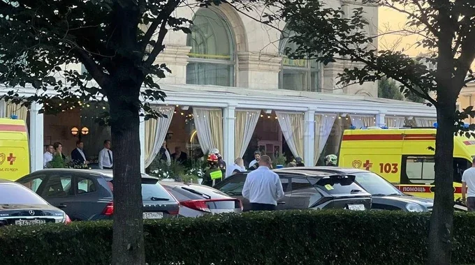 Швидкі допомоги, люди та авто біля білого павільйону ресторану в Москві